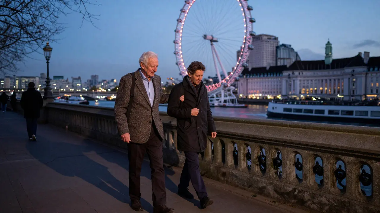 An elderly man walks along the Thames at dusk with a companion, smiling as they enjoy the view.